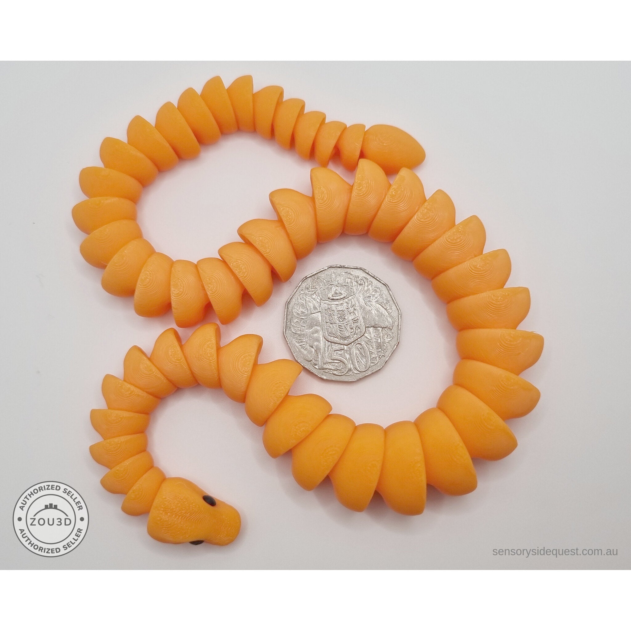 Orange 3D printed ball python fidget toy in S-curve pose beside Australian 50 cent coin — scale reference showing full body length