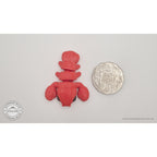 Baby Lobster 3D printed fidget toy in red silk next to Australian 50c coin for size reference — flat-lay overhead