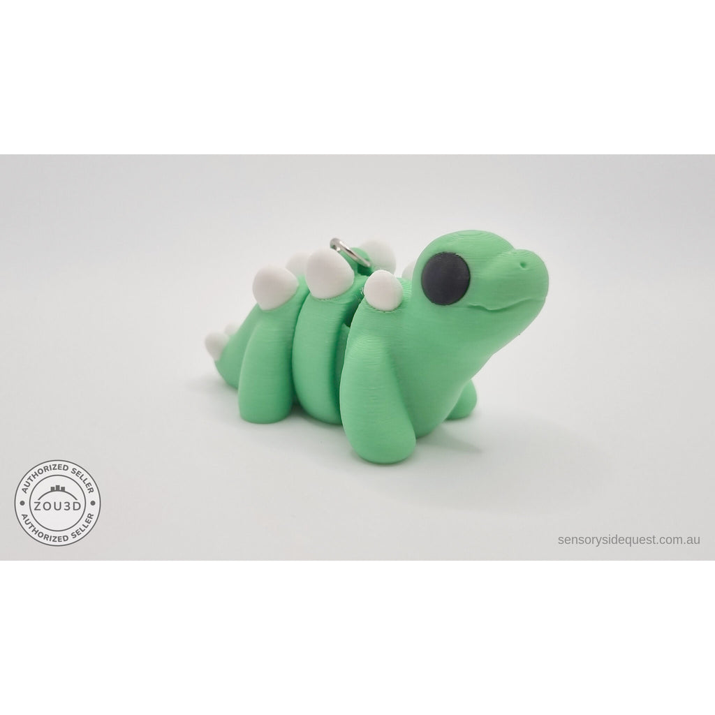 Baby Stegosaurus keychain — left side profile showing full body with keychain hardware