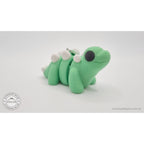 Baby Stegosaurus keychain — left side profile showing full body with keychain hardware