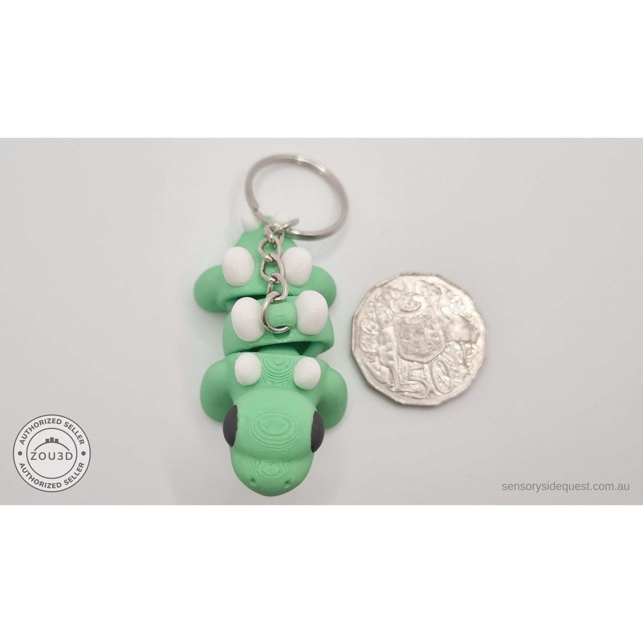 Baby Stegosaurus keychain beside Australian 50 cent coin — scale reference