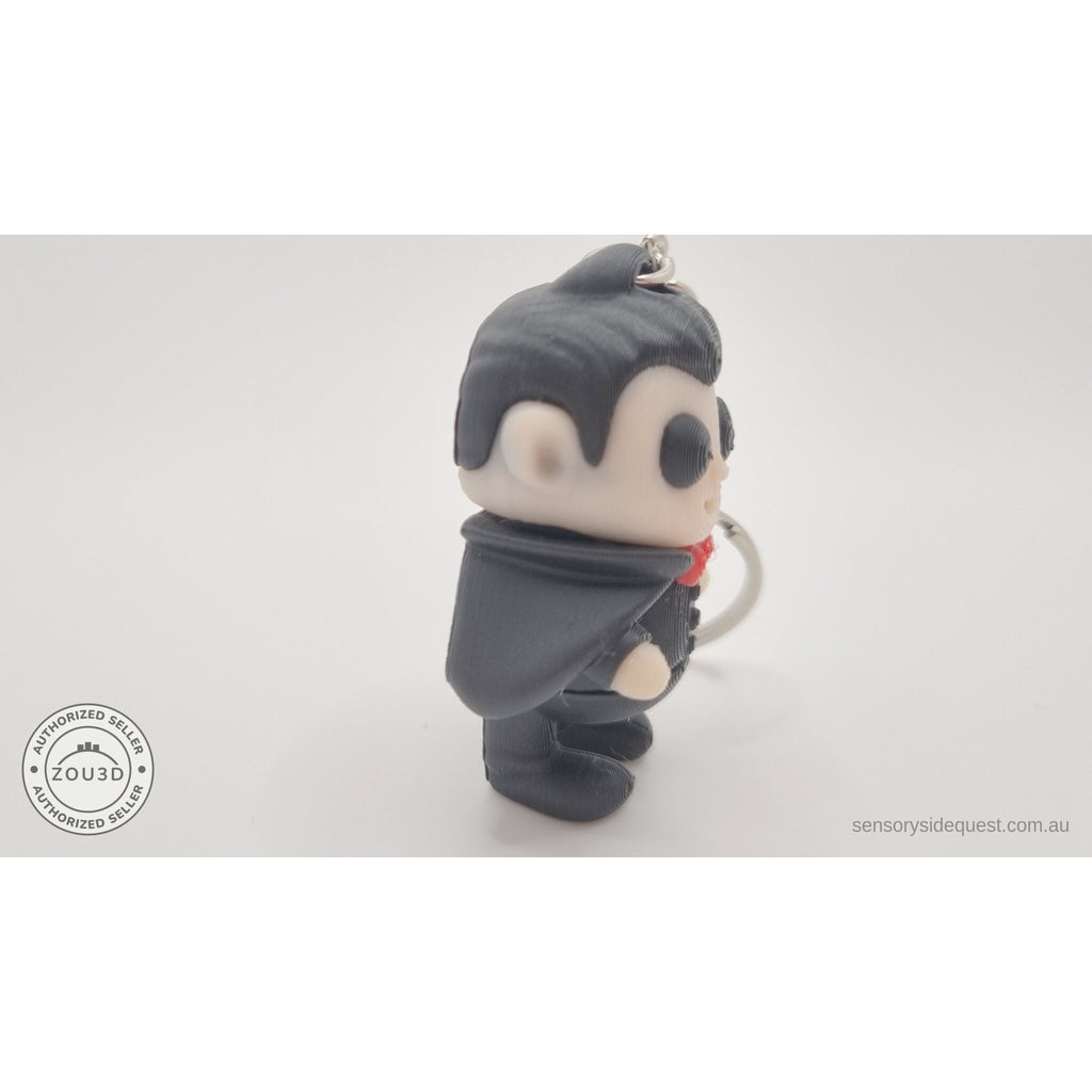 Tiny Dracula keychain articulated toy — 3/4 side view showing cape and ring, own photo by Sensory Sidequest