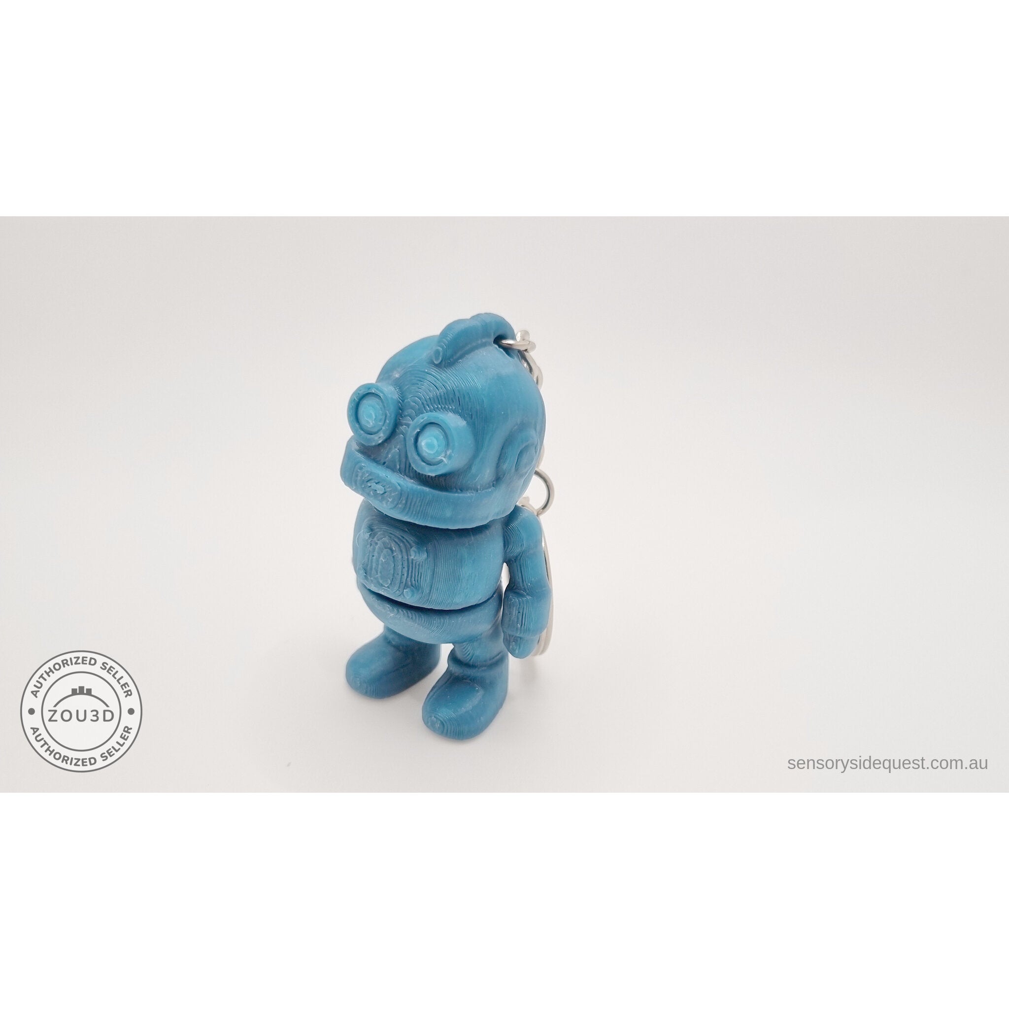 Tiny Robot 3D printed fidget toy keychain variant in teal — close 3/4 front view showing circular eyes and keychain ring — Sensory Sidequest