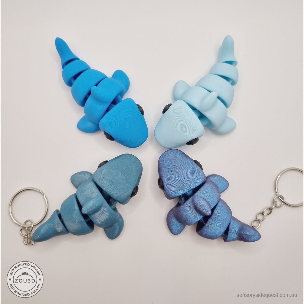 024-SHK Baby Shark group shot — four colour variants overhead including two keychain versions with hardware visible