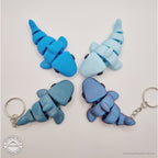 024-SHK Baby Shark group shot — four colour variants overhead including two keychain versions with hardware visible