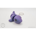 027-TNYSHK Tiny Shark keychain in crushed electric purple — 3/4 front view from lower angle showing face detail and body segments with vibrant purple shimmer — 3D printed articulated fidget toy by Sensory Sidequest