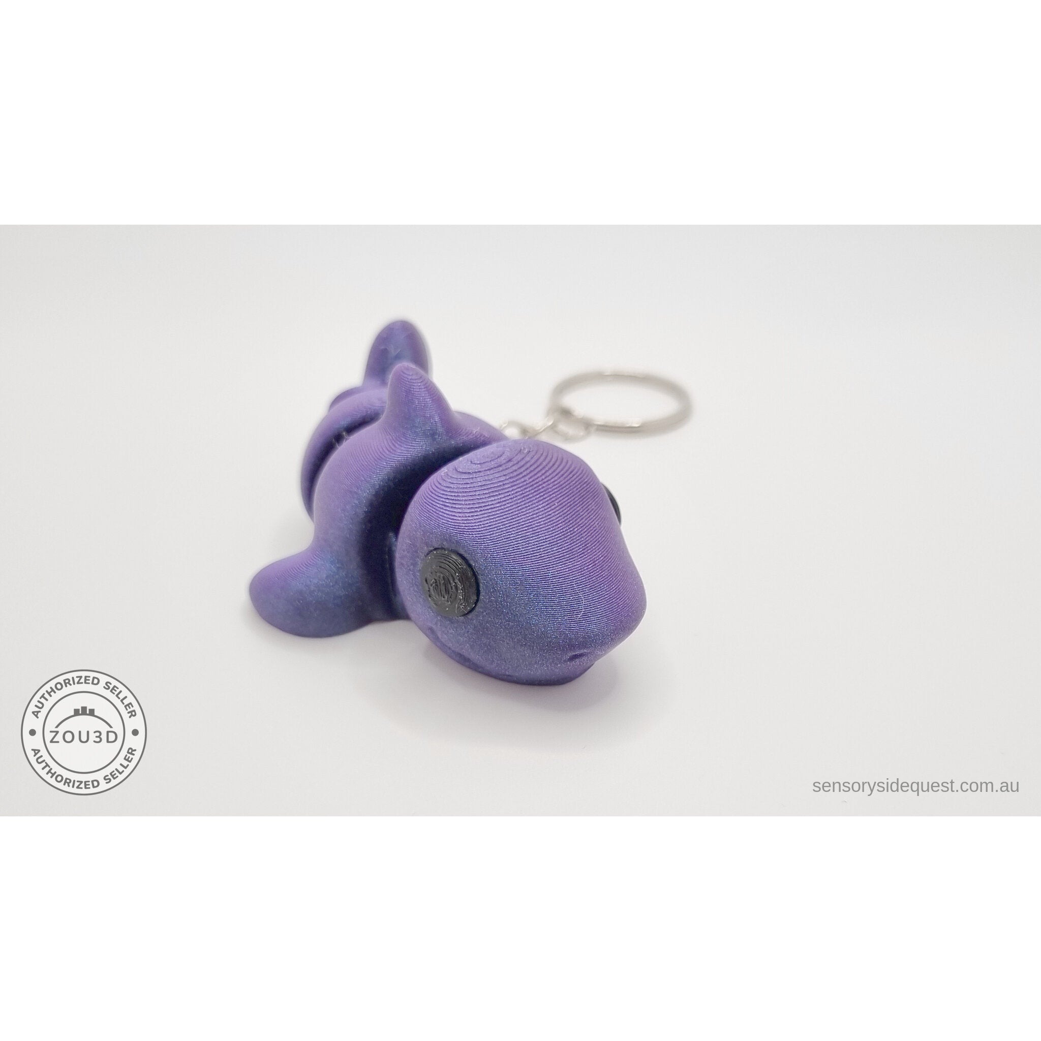 027-TNYSHK Tiny Shark keychain in crushed electric purple — 3/4 front view from lower angle showing face detail and body segments with vibrant purple shimmer — 3D printed articulated fidget toy by Sensory Sidequest