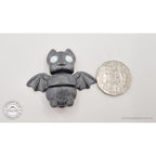 Tiny Bat with white eyes beside Australian 50 cent coin — scale reference