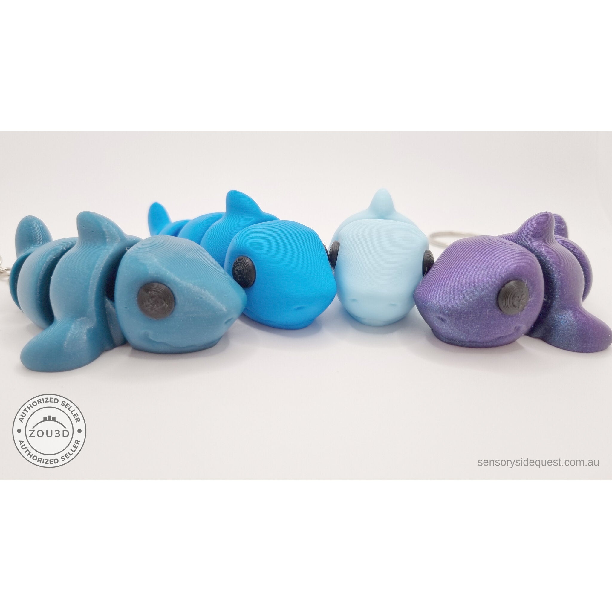 024-SHK Baby Shark group shot — four colour variants lined up side-by-side showing colour range (teal keychain, cyan, ice blue, purple metallic)