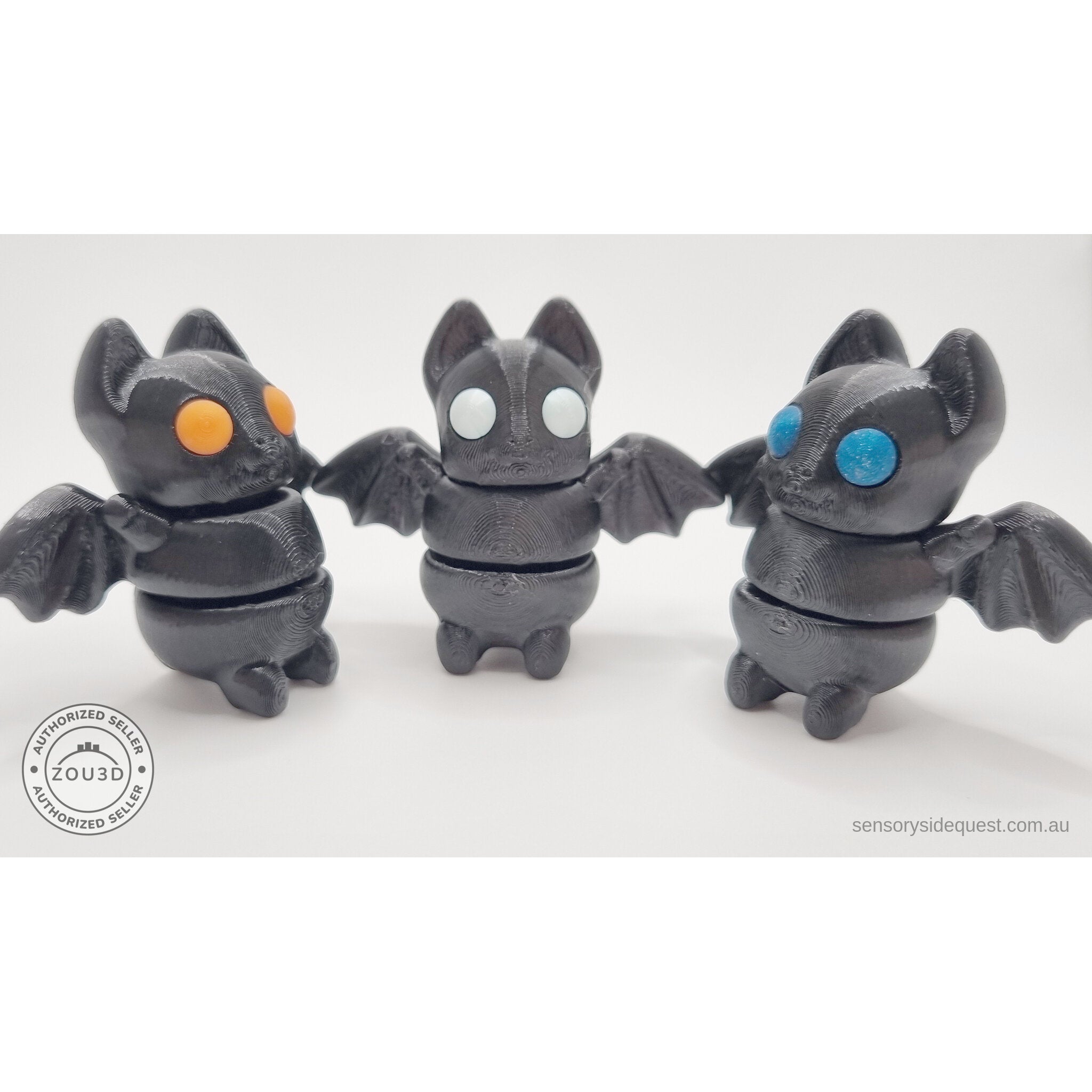 Three Tiny Bat variants side by side — orange, white, and blue eye colours — group shot