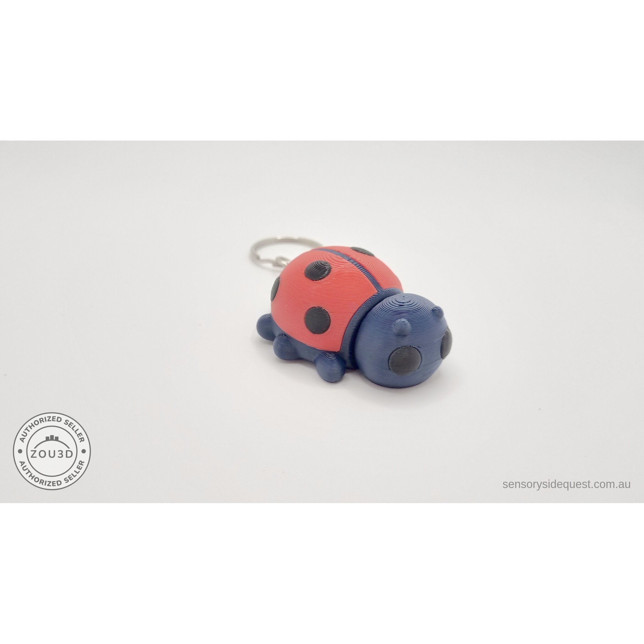 Baby Ladybug keychain — three-quarter front view showing red elytra and navy body with keyring