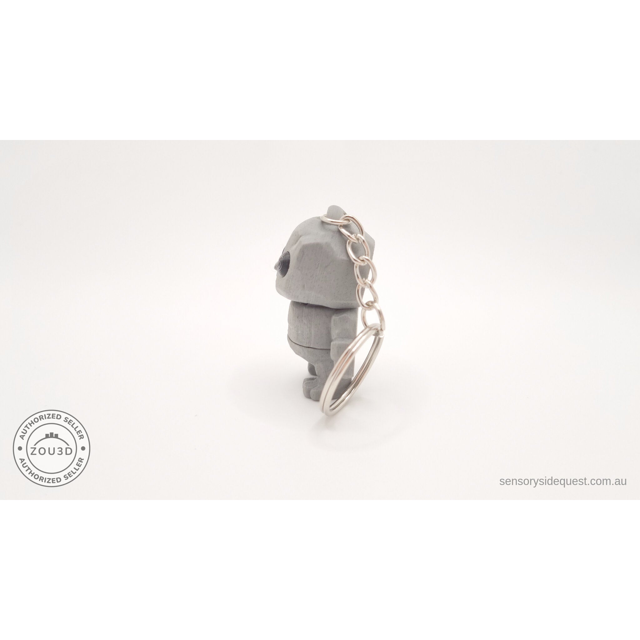 Grey Tiny Rock Golem keychain — back view showing articulation by Sensory Sidequest