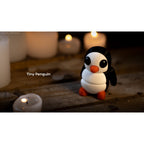 Penguin articulated fidget toy designer lifestyle render, front-facing view with candles, showing classic white and black penguin design with orange accents — 3D printed articulated fidget toy by Sensory Sidequest