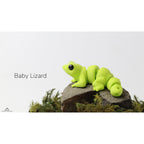 Baby Lizard (ZOU3D) articulated fidget toy — official render, 3/4 side view on mossy rock