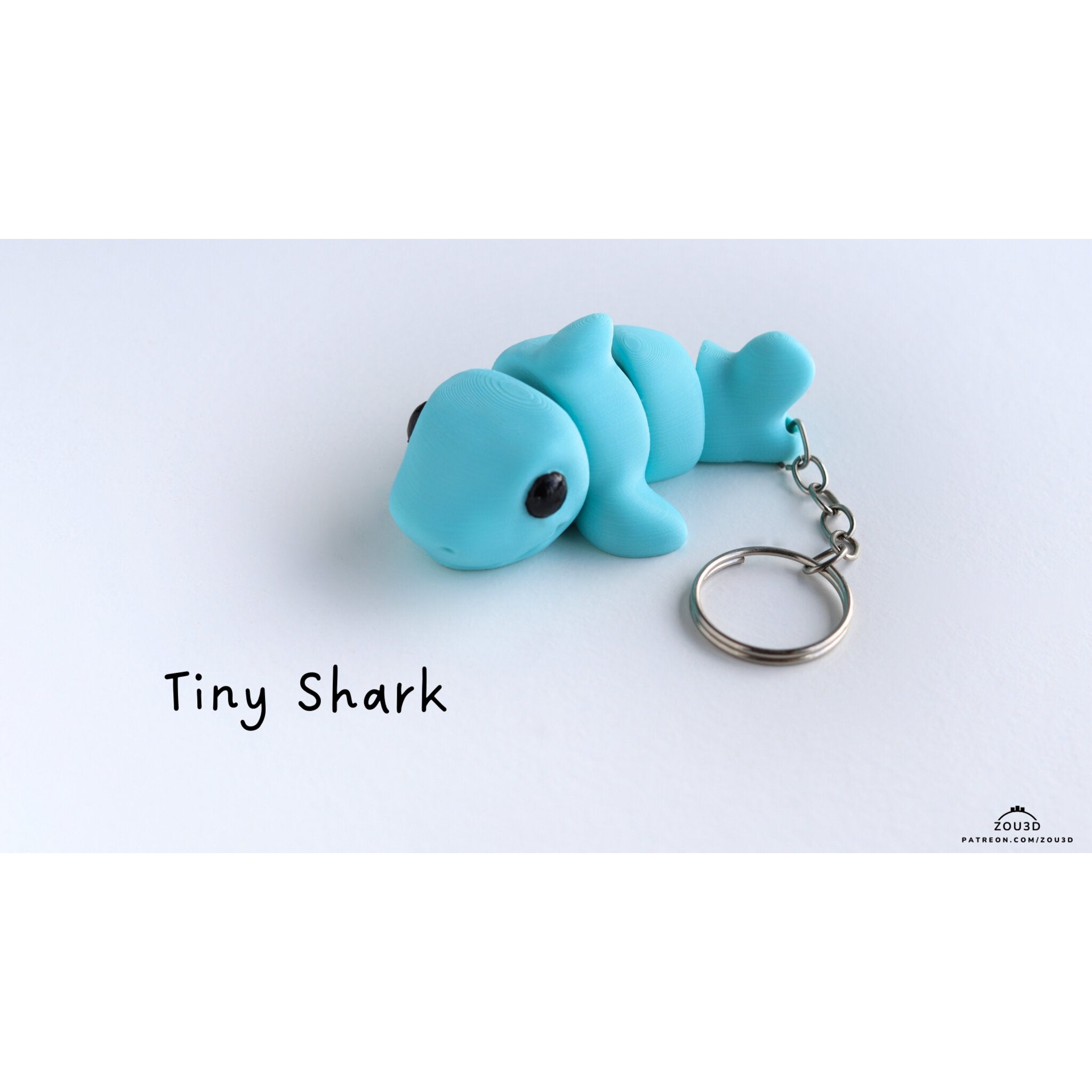 027-TNYSHK Tiny Shark — designer stock render, 3/4 front hero view showing keychain hardware and classic blue colourway with "Tiny Shark" title — by Zou3D