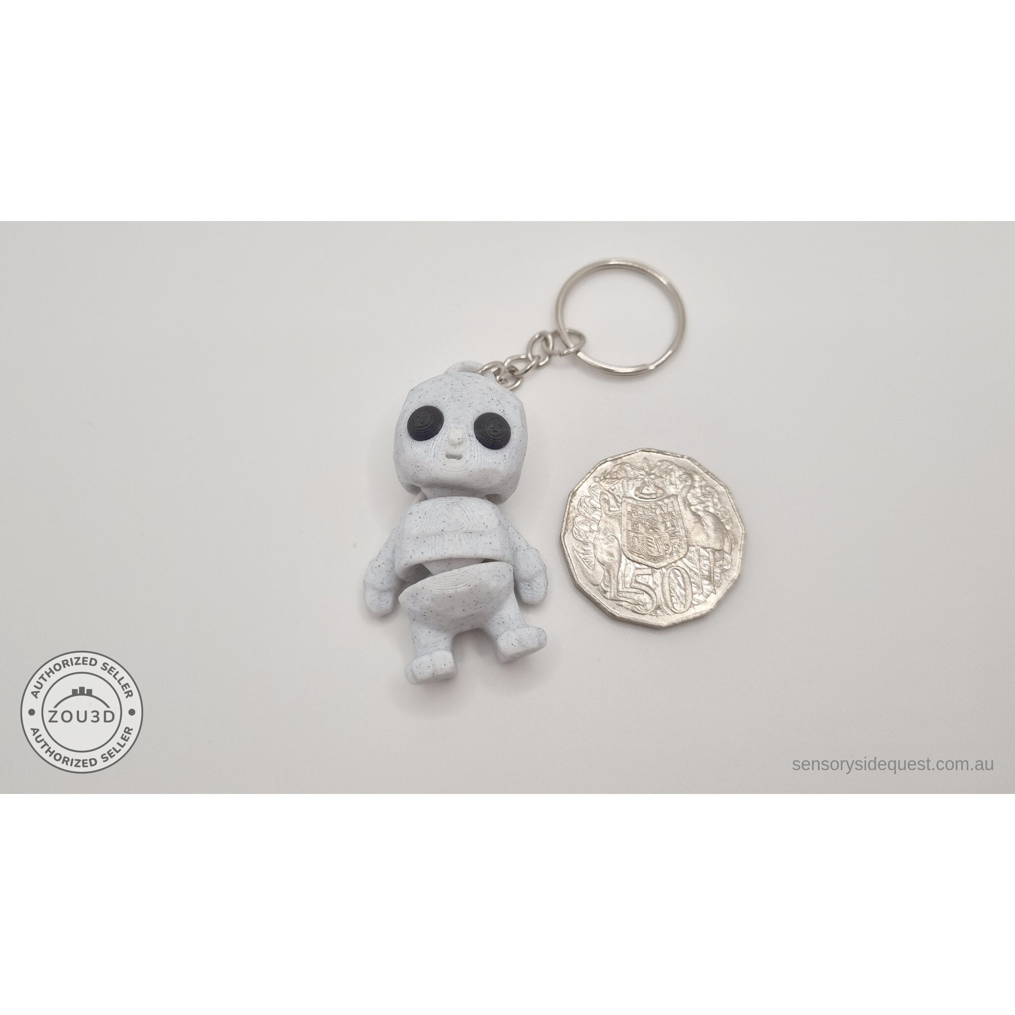 White granite Tiny Rock Golem keychain beside Australian 50-cent coin — scale reference by Sensory Sidequest