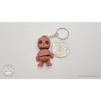 Terracotta Tiny Rock Golem keychain beside Australian 50-cent coin — scale reference by Sensory Sidequest