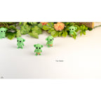 Green Tiny Goblin ZOU3D articulated toy — group of four figures with foliage background