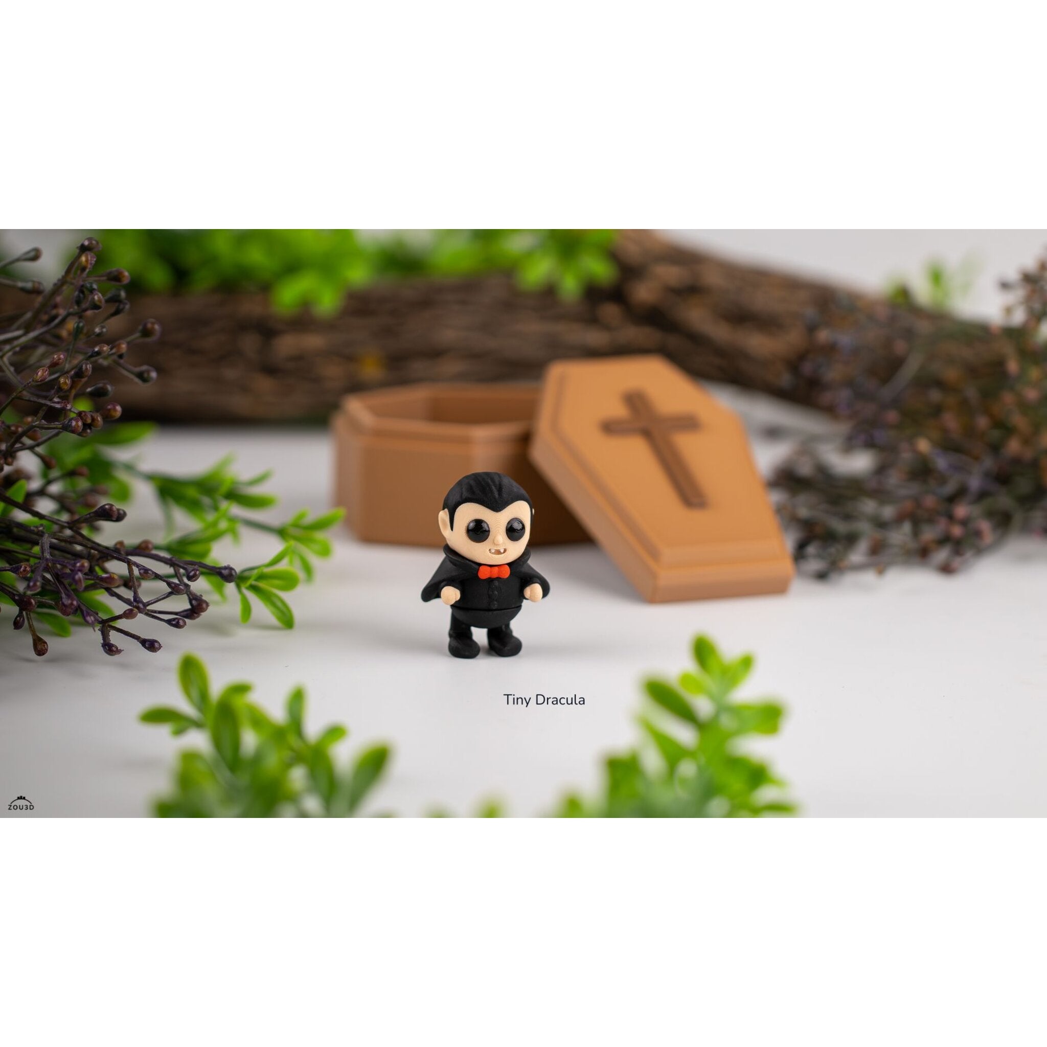 Tiny Dracula 3D printed articulated figure standing in front of open wooden coffin prop with Halloween foliage