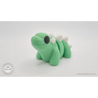 Baby Stegosaurus articulated fidget toy — three-quarter front view showing back plates and eye