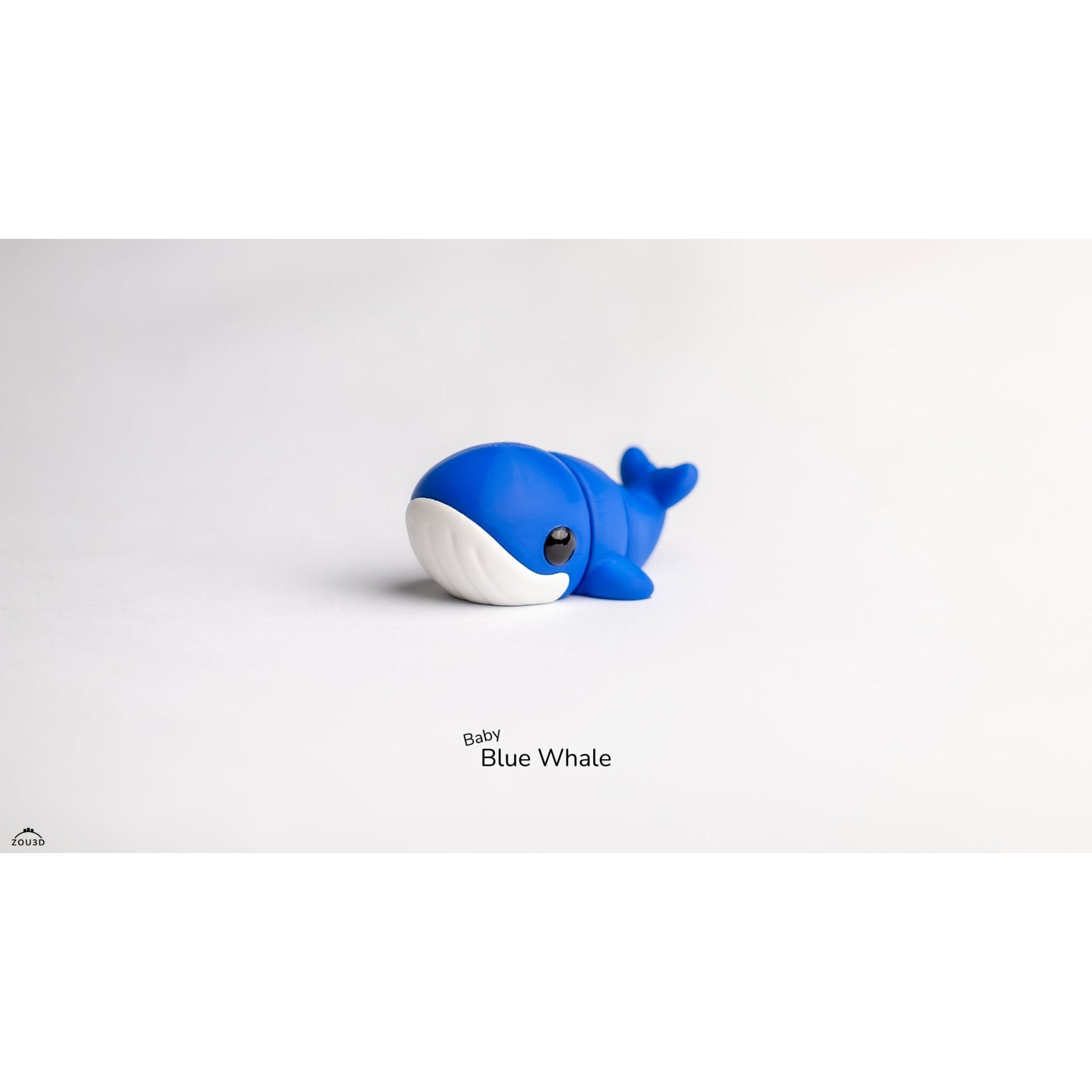 Close front three-quarter view of Baby Blue Whale 3D printed articulated toy highlighting white belly panel and large eye detail