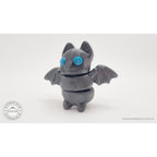 Tiny Bat articulated fidget toy — blue eye variant, front-facing view showing wings and segmented body