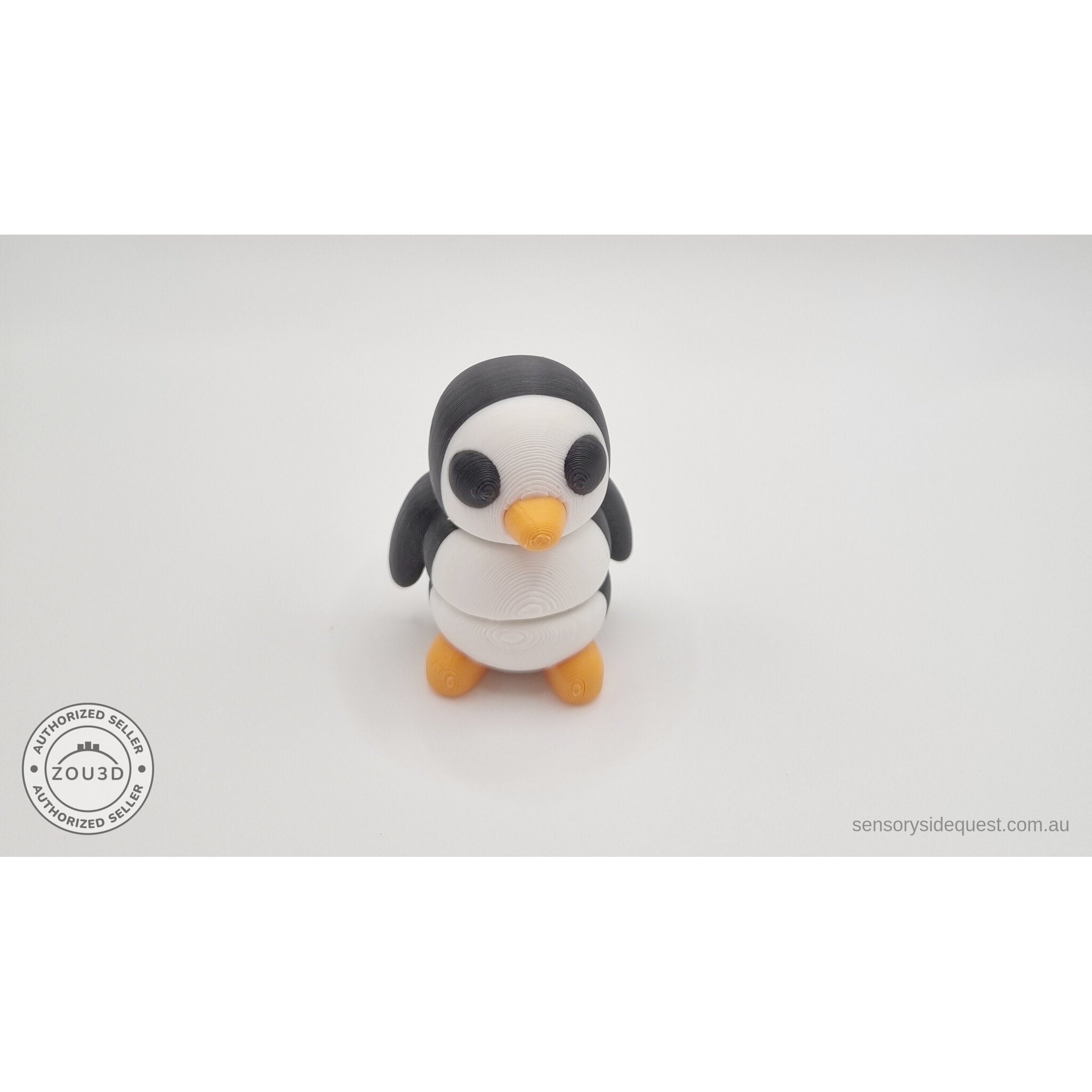 Penguin articulated fidget toy overhead flat lay showing front face, white body with black head markings and orange beak — 3D printed articulated fidget toy by Sensory Sidequest