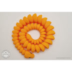 Overhead view of orange 3D printed ball python fidget toy coiled in a full spiral, showing scale texture on every segment