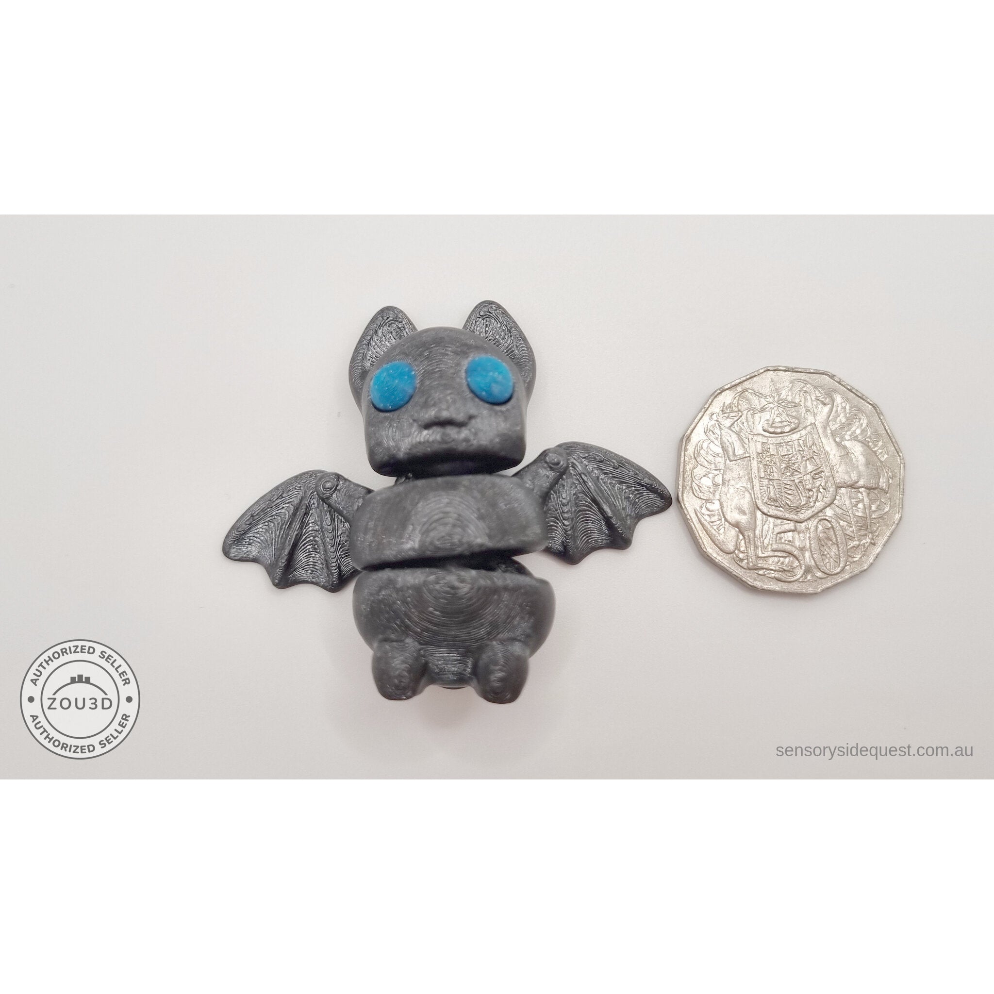 Tiny Bat with blue eyes beside an Australian 50 cent coin showing compact palm size