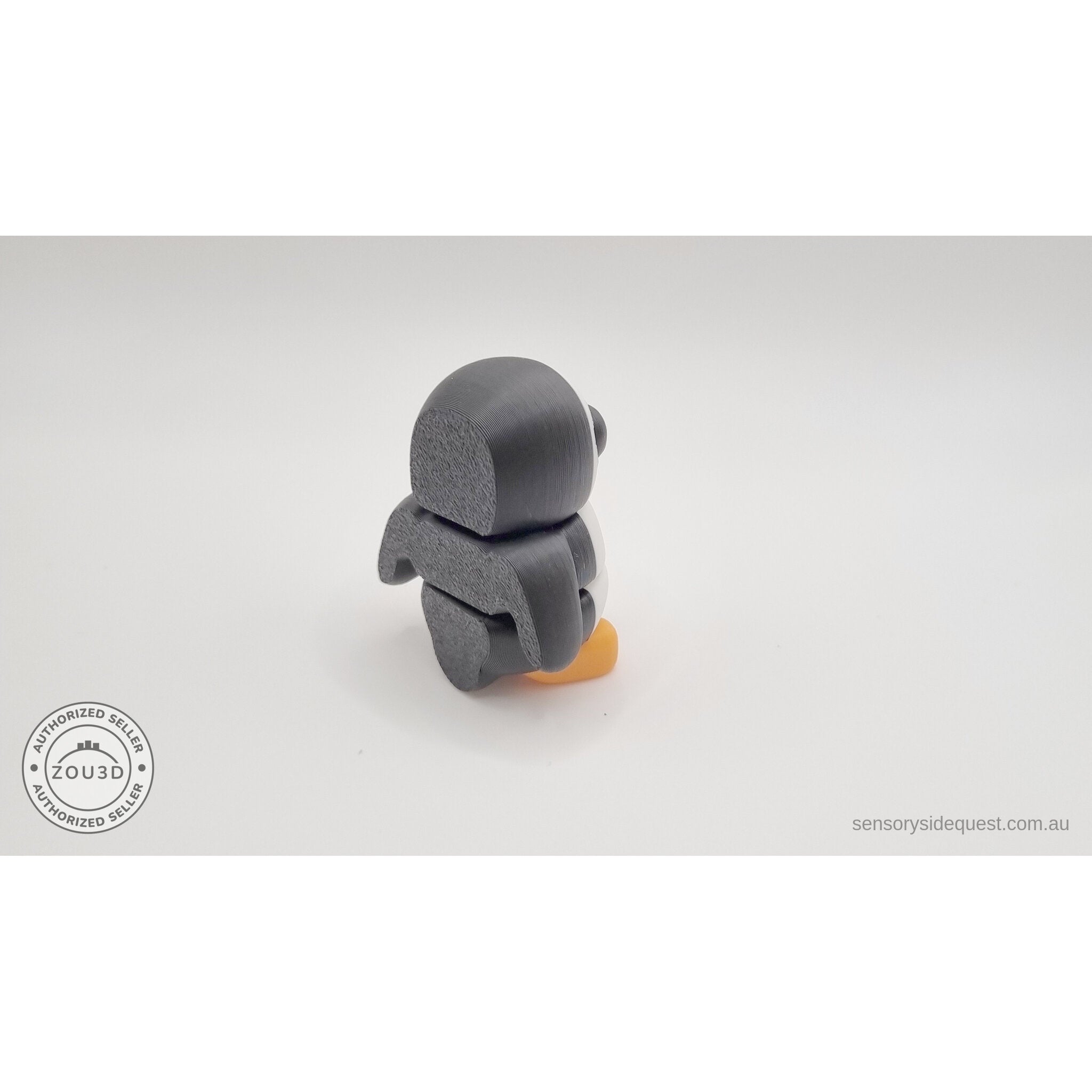 Penguin articulated fidget toy close 3/4 left profile view, white and black colouring with orange beak and feet clearly visible — 3D printed articulated fidget toy by Sensory Sidequest