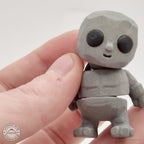 Grey Tiny Rock Golem 3D printed articulated fidget toy held in hand — scale reference