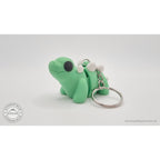 Baby Stegosaurus keychain — three-quarter front view showing ring and chain hardware